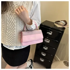 Detailed close-up of pink handbag with sequins, golden logo, and elegant handle