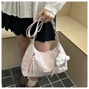Nahaufnahme hellrosa Tasche mit Perlenkette und weißem Plüsch-Wolkenanhänger