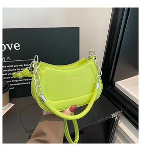 Detailansicht der lindgrünen Halbmondtasche mit Silberkette und Fashion-Schriftzug