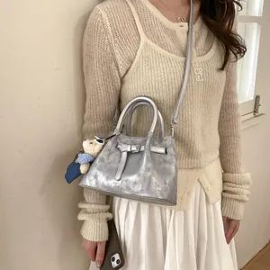 Silver metallic bucket bag with leather buckle detail and cute teddy bear charm