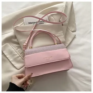 Detail of pink glossy handbag with silver trim and CAHRES & HEKA brand gold lettering