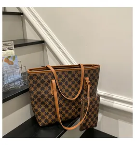 Detail of retro monogram tote bag set with matching pouch on minimalist stone stairs