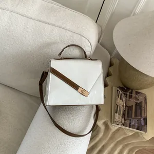 Detail of white PU leather texture and gold buckle on a retro crossbody handbag