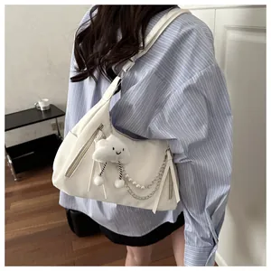 Detalle del bolso de media luna blanco con colgante de nube y cadena de perlas