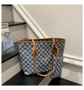 Detail view of a retro tote bag and small pouch set featuring blue and white M-pattern fabric