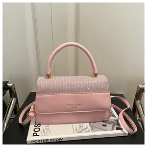 Detail of pink patchwork handbag featuring crystal-encrusted flap and golden hardware