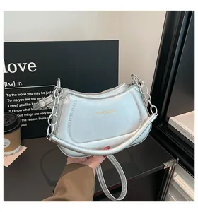 Detail der silbernen Metallic-Tasche mit Kettenriemen und glatter PU-Lederstruktur