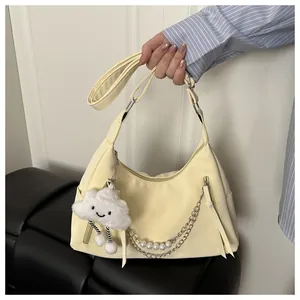 Detailansicht beige Hobo-Tasche mit Perlenkette und weißem Wolken-Plüschanhänger