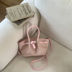Detailed close-up of pink woven texture on a stylish bucket bag with top handle