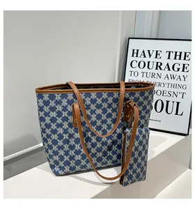 Detail view of the navy blue tote bag set with M-pattern jacquard and brown leather handles