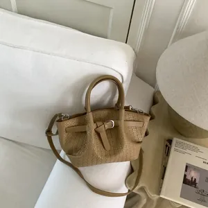 Detail shot of the woven texture and silver buckle on khaki bucket bag in cozy room