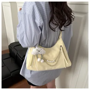 Detalle de bolso bandolera amarillo media luna con cadena de perlas y colgante de nube