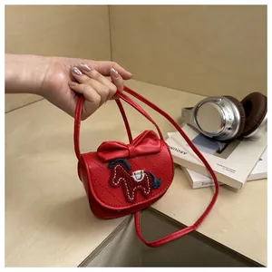 Detail van rode gewatteerde mini-crossbodytas met lederen strik en borduuraccenten