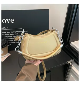 Detailansicht der goldenen halbrunden Schultertasche mit eleganter Kette und Lederband