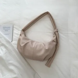 Detailaufnahme einer beigen Crescent-Tasche mit Plisseefalten und Knotengurt-Design