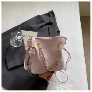 Pink quilted bucket bag detail with gold chain strap and leather drawstring accent
