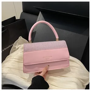 Detail of pink faux leather handbag with shimmering rhinestone flap and gold logo