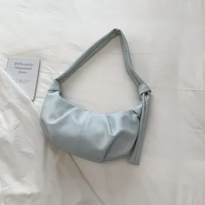 Detailansicht der hellblauen Sichel-Tasche mit Falten-Lederstruktur und seitlichem Knotendesign