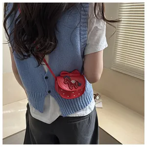 Detail van de rode crossbodytas met borduursel en hartjespatroon gedragen door een model