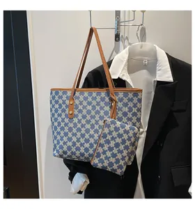 Detailed macro view of tote bag set featuring blue geometric patterns and brown leather straps