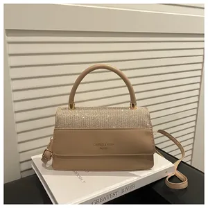Detail showing apricot handbag with rhinestone flap cover and gold metal hardware