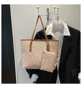 Close-up of pink monogram tote bag with brown leather handles and small matching pouch