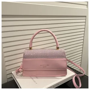 Macro detail of pink leather handbag featuring sparkling rhinestone inlay and silver hardware