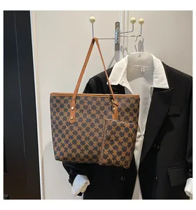 Detail of retro monogram tote bag with matching pouch and gold rivet accents