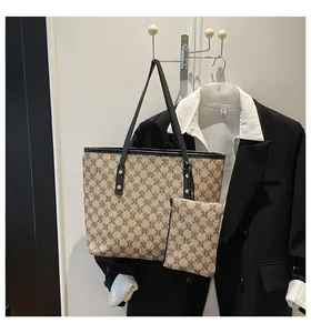 Detailed view of the khaki monogram tote bag set with black trim on a hanger with a suit