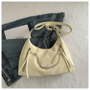 Detalle de bolso blanco crema en cuero PU con elegante cadena de perlas y cremalleras