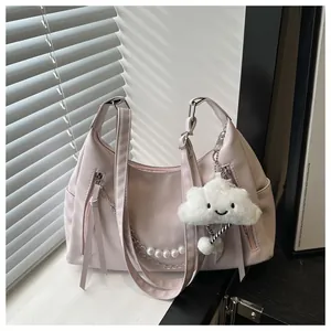 Detalle del bolso de hombro rosa de PU con cadena de perlas y colgante de nube de peluche