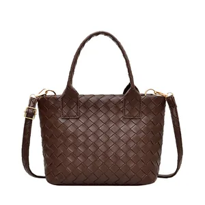 Minimalist woven dark brown leather handbag with adjustable crossbody strap and top handle