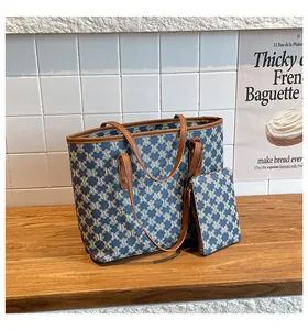 Detail of blue and white letter jacquard tote bag with matching zippered pouch and leather trim