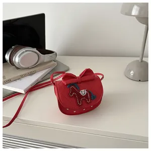 Detail van rode gewatteerde crossbodytas met strik en paardenborduurwerk