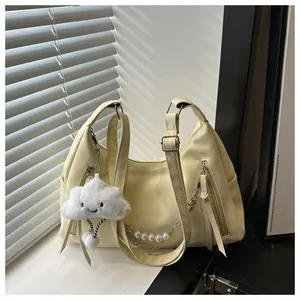 Detalle de bolso bandolera de cuero PU amarillo claro con cadena de perlas y colgante nube