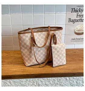 Macro view of vintage large tote bag with repetitive M pattern and brown leather trim