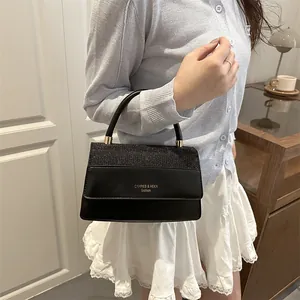 Elegant black handbag with glitter patchwork and golden fashion logo for women