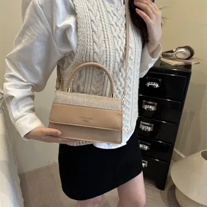 Elegant beige square handbag with sparkling rhinestone flap and rounded metal handle