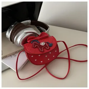 Detail van rode PU-leren minitas met strik, pony-borduurwerk en witte hartpatronen