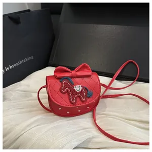 Detail van rode leren crossbodytas met strik, borduursel en gewatteerde textuur