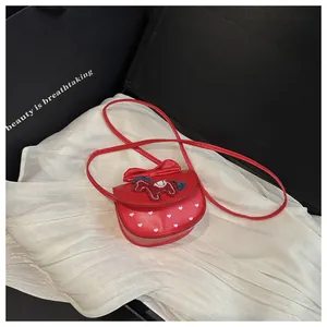 Detail van rode crossbodytas voor kinderen met strik, hartjes en paardenborduurwerk