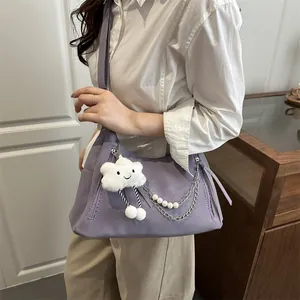 Bolso bandolera morado de moda con colgante de nube y cadena de perlas en una modelo