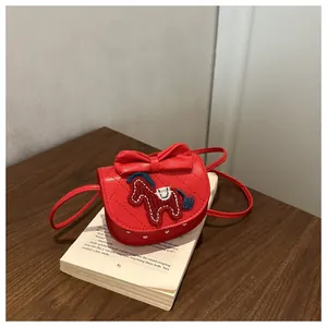Macro detail van rode kunstlederen mini tas met strik accent en paard borduur