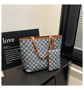 Detail view of denim-style tote bag set with blue M-pattern print and brown leather handles
