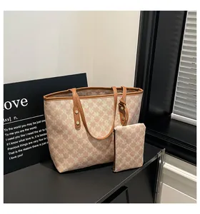 Detail of monogram tote bag with matching pouch and brown leather trim accents