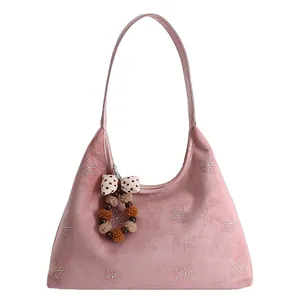 Pink suede hobo bag featuring rhinestone flower pattern and plush pendant charm