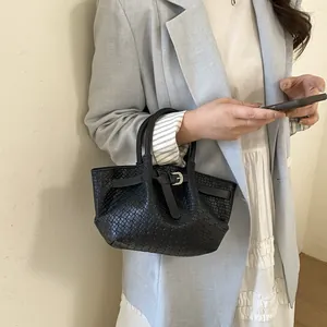 Chic black woven bucket bag with handles styled with a blue blazer and white skirt