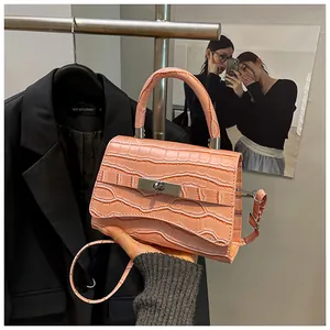 Detailed shot of pink crocodile pattern handbag with silver metal lock and top handle