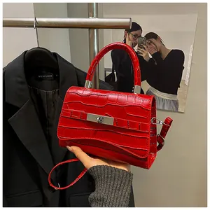 Close-up of red crocodile embossed leather handbag with silver metal buckle detail