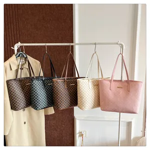 Detailed display of five stylish monogram tote bags hanging on a modern white clothes rack